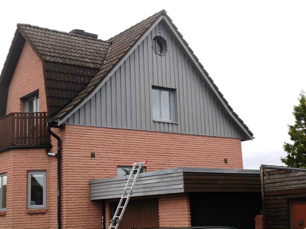 Fasadrenovering av villa i Malmö med tegel- och träfasad
